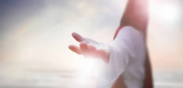 Resurrected Jesus Christ reaching out with open arms in the sky, heaven and cross, love and salvation concept